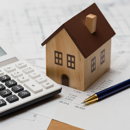 Een modulaire woning met een pen en een rekenmachine.